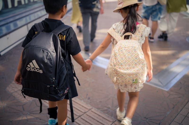 Parent and student walking to school with backpacks